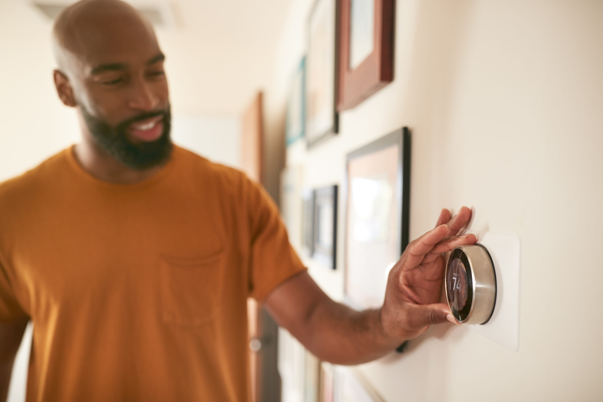 Dallas homeowner adjusting smart thermostat